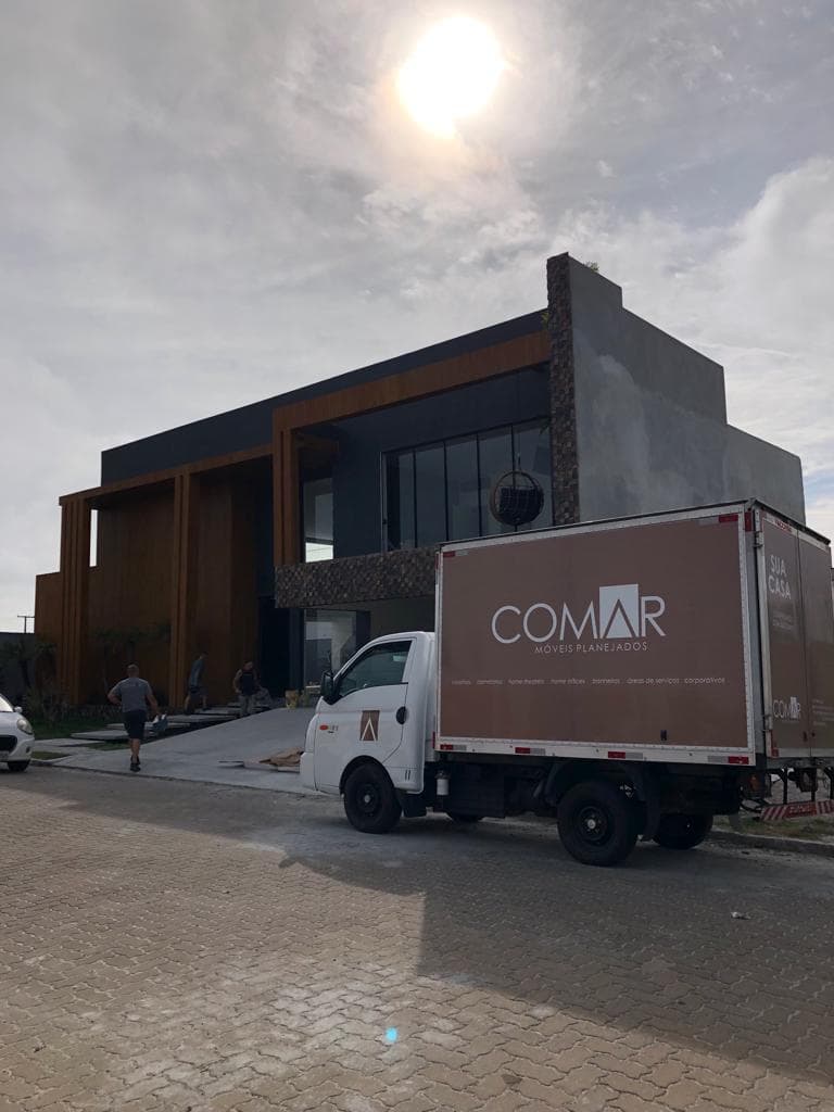 Veículo da Comar em frente a uma casa durante uma entrega