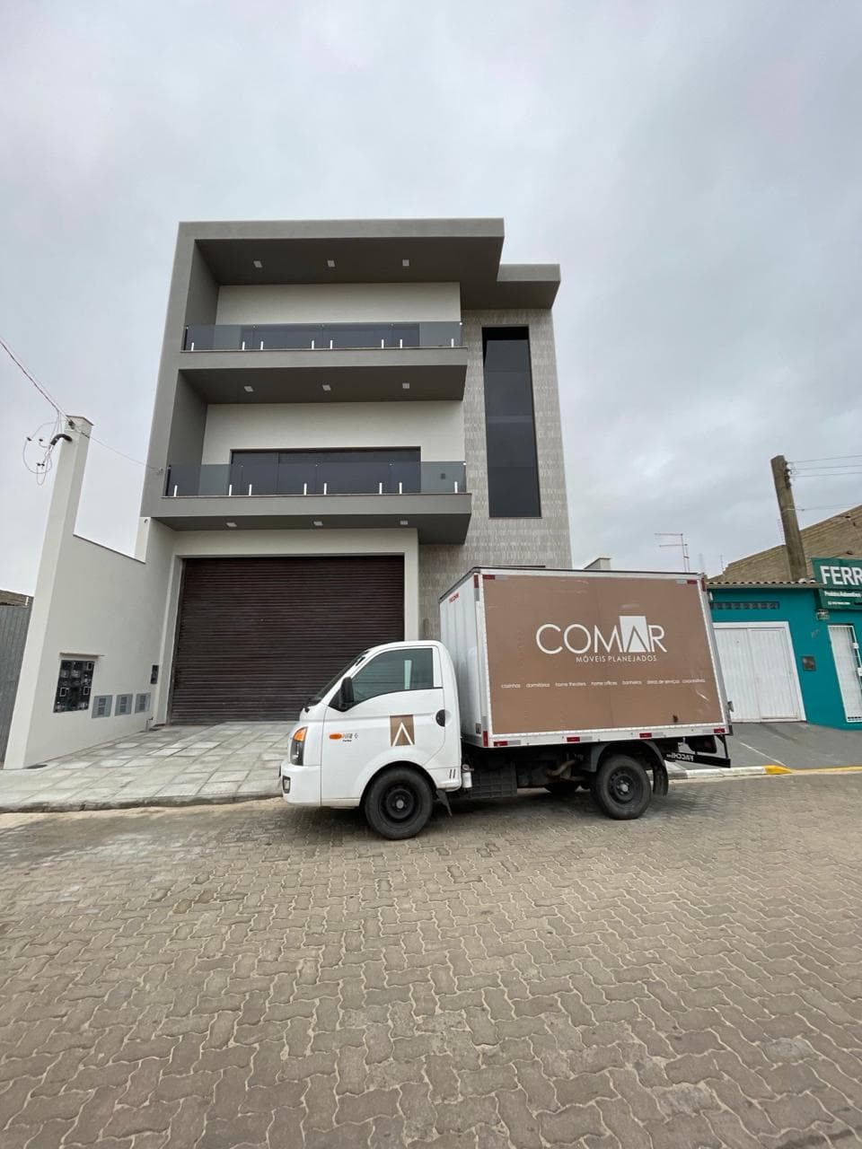 Caminhão da Comar em frente a um prédio residencial